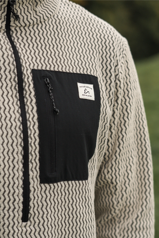 Atmungsaktiver beiger Half Zip Skirolli für Herren mit Brusttasche. Idealer Midlayer von The Clue Clothing für kalte Tage auf der Piste.